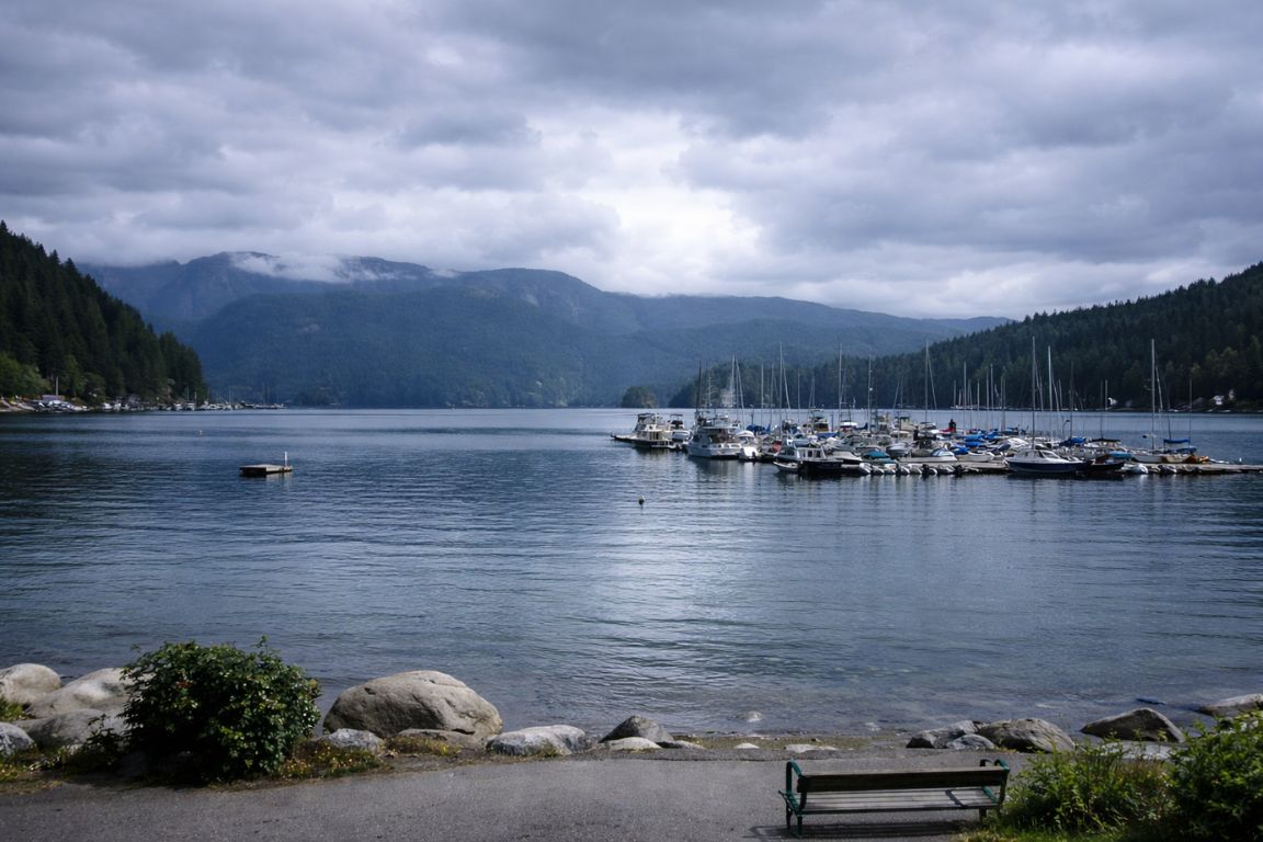 Horseshoe Bay marina with boats and mountain backdrop under cloudy sky captured during a tour with Tofino Tour Packages